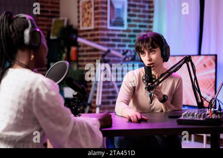 Moderatorin einer Online-Show, die Gespräche mit Frauen über die Ereignisse der letzten Woche während eines Podcasts mit Schwerpunkt auf Nachrichten führt. Talking Show Interviewer im Wohnzimmer Studio Streaming Gespräch im Internet Stockfoto