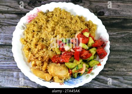 Ägyptischer Reis auf heißem Dampf gekocht, grüner Salat und gebratener Tintenfisch, eine Weichtiere mit langem, weichem Körper, großen Augen, acht Armen und zwei Tentakeln in der Th Stockfoto