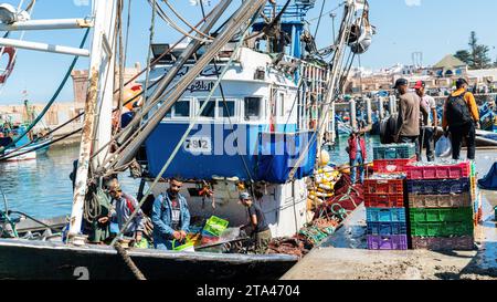 Essaouira, Marokko - 17. September 2022: Fischer auf einem traditionellen blauen Fischerboot, die von der Segel zurückkehren und den Tagesfang zum Hafen von es bringen Stockfoto