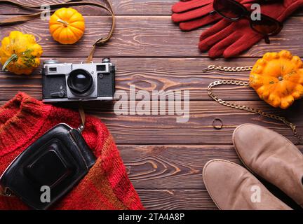 Komposition mit weiblicher Kleidung, Accessoires und Kürbissen auf hölzernem Hintergrund Stockfoto