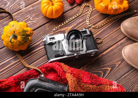 Komposition mit weiblicher Kleidung, Accessoires und Kürbissen auf hölzernem Hintergrund Stockfoto