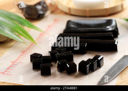 Gewürfelte schwarze Grasgelee oder Cincau Hitam, indonesisches Dessert aus Cincau Leaf, normalerweise mit Kokosmilch und Palmzuckersirup. Beliebt bei Tak Stockfoto