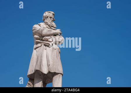 Kontemplative bärtige Männerstatue im langen Mantel vor blauem Himmel in Venedig. Stockfoto