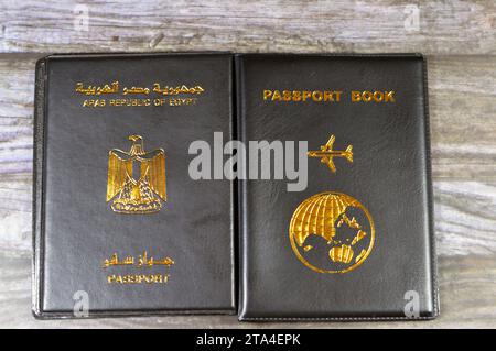 Ägyptischer Pass Schwarzes Buch, Übersetzung arabischer Wörter (Pass der Arabischen republik Ägypten) und Schwarzes Passbuch mit einem Flugzeug und der Erde Stockfoto