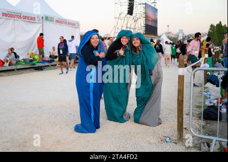 Junge französische Pilger, die morgens in ihren Schlafsäcken im Parque Tejo – Campo da Graca spazieren gehen. Weltjugendtage 2023 in Lissabon, Portugal. Stockfoto