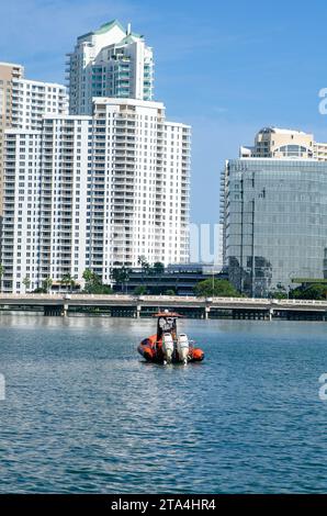 Rotes Boot in einer Bucht mit Gebäuden im Hintergrund unter blauem Himmel. Stockfoto