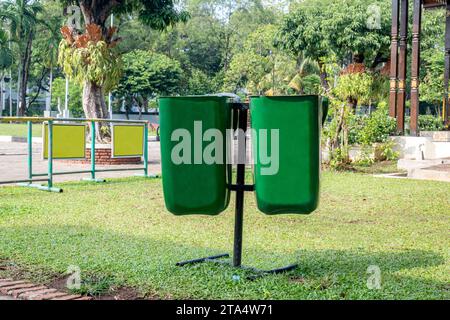 Grüne Mülltonnen hängen im Park Stockfoto