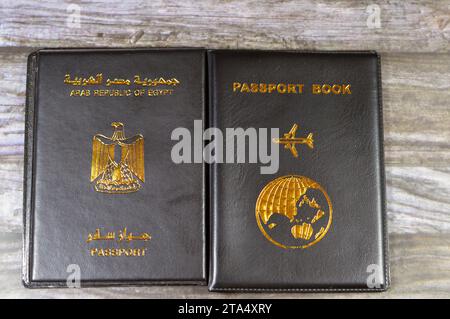 Ägyptischer Pass Schwarzes Buch, Übersetzung arabischer Wörter (Pass der Arabischen republik Ägypten) und Schwarzes Passbuch mit einem Flugzeug und der Erde Stockfoto