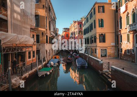 Malerischer schmaler Kanal in Venedig, Italien mit traditioneller Architektur und Gondeln Stockfoto