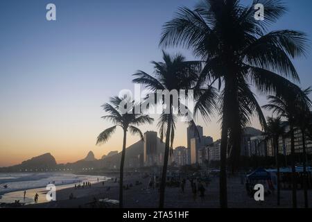 Leme und Copacabana Strand bei Sonnenuntergang, durch Kokospalmen gesehen, Rio de Janeiro, Brasilien. Stockfoto