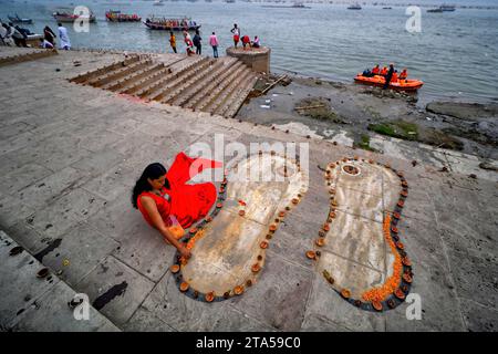 Varanasi, Indien. November 2023. Ein junges Mädchen mit einem bunten Kleid, das am Vorabend von Dev Deepavali schmückt. Dev Deepavali, auch bekannt als Diwali der Götter, ist ein fest, das auf Karthik Purnima gefeiert wird, das 15 Tage nach Diwali fällt. Dev Deepavali ist das größte Lichtfestival Indiens, bei dem die Gläubigen das Ufer des Ganges mit Millionen von Lampen als Teil des Festivals schmücken. Quelle: SOPA Images Limited/Alamy Live News Stockfoto