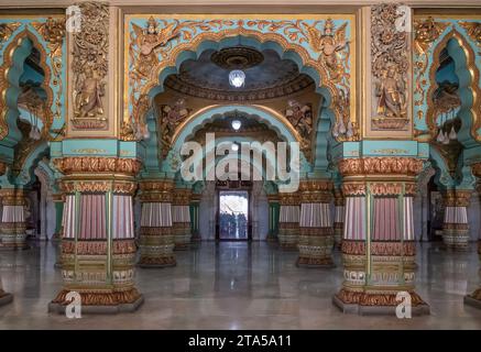 Wunderschön dekorierte Innendecke und Säulen der Durbar oder des Audienzsaals im königlichen Mysore Palace. Zeremonieller Versammlungssaal des Königs C. Stockfoto