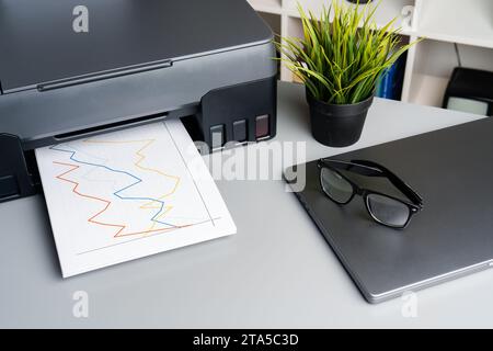 Neuer moderner Drucker und Laptop im Büro auf dem Tisch Stockfoto