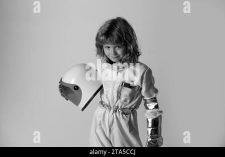 Das kleine Kind will einen Astronauten-Helm im Weltraum tragen. Speicherplatz kopieren. Innovation und Inspiration für Kinder. Stockfoto