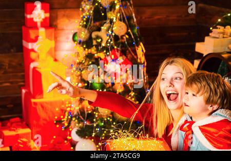 Zeigen Sie Ihrem Kind, dass Ihr Produkt angezeigt wird. Familienkonzept. Aufgeregt, glücklich, Weihnachten, glückliche Familie. Stockfoto