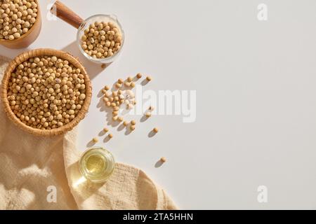 Ein Glas Sojaöl, dekoriert mit einigen Schüsseln, die viele Sojasamen und ein Handtuch enthalten. Kopierbereich. Sojaöl ist eine reiche Quelle für Linolsäure Stockfoto