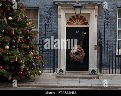 London, Vereinigtes Königreich. November 2023. Der Eingang zur Downing Street 10 ist mit einem traditionellen Weihnachtsbaum und einem Kranz an der Tür dekoriert. Stockfoto