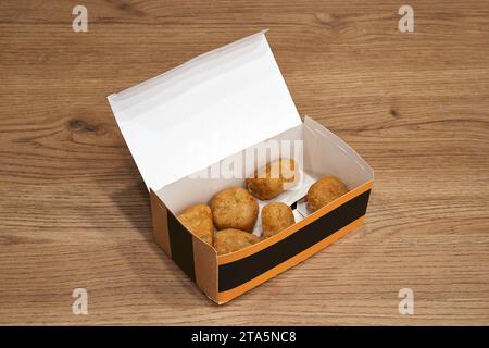 Lieferung Bastelbox mit frittierter Vorspeise auf Holztisch Stockfoto