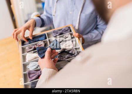 Der Kunde wählt eine Fliege aus einer Kollektion in einem Schneidergeschäft Stockfoto