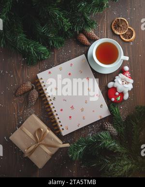 Eine schöne Komposition mit einem Notizbuch, Tassen Tee, auf einem Holztisch. Stockfoto