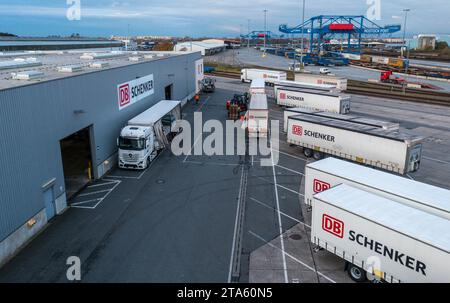 Rostock, Deutschland. November 2023. Lkw des Logistikunternehmens DB Schenker werden auf dem Gelände des Logistikzentrums im Seehafen entladen. (Luftaufnahme mit Drohne) die Logistikgesellschaft der Deutschen Bahn betreibt mehrere Logistikzentren in Mecklenburg-Vorpommern. Quelle: Jens Büttner/dpa/Alamy Live News Stockfoto