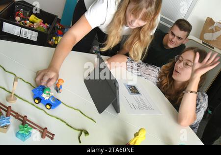 19. Oktober 2023, Sachsen, Leipzig: In einem neu geschaffenen digitalen Klassenzimmer am Zentrum für Lehrerbildung und Schulforschung (ZLS) der Universität Leipzig erstellen Lehrstudenten verschiedener Semester während eines Blockseminars ein Stop-Trick-Video mit Lego-Figuren und einem iPad. Der digitale Klassenzimmer ist mit moderner Technologie ausgestattet und soll Lehrern und Schülern die mögliche Nutzung von künstlicher Intelligenz (KI) und den Einsatz von Podcasts im Klassenzimmer unter anderem mittels Videotechnologie, iPads, 3D-Druckern und Virtual-Reality-Tools zeigen. Angehende Lehrer können Erfahrungen machen und versuchen Stockfoto