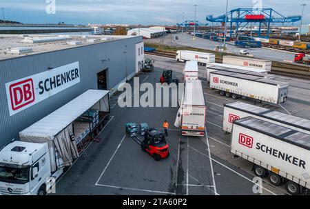 Rostock, Deutschland. November 2023. Lkw des Logistikunternehmens DB Schenker werden auf dem Gelände des Logistikzentrums im Seehafen entladen. (Luftaufnahme mit Drohne) die Logistikgesellschaft der Deutschen Bahn betreibt mehrere Logistikzentren in Mecklenburg-Vorpommern. Quelle: Jens Büttner/dpa/Alamy Live News Stockfoto