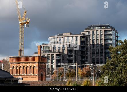 Stadterneuerung in London UK. Regent's Canal am Kings Cross, mit neu erbauten Wohnblocks und historischem viktorianischen Backsteinturm auf der linken Seite. Stockfoto