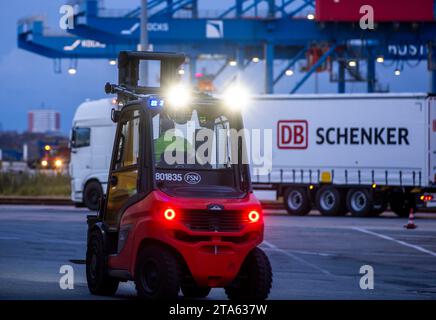 Rostock, Deutschland. November 2023. Paletten und transportierte Güter werden von Anhängern des Logistikunternehmens DB Schenker auf dem Gelände des Logistikzentrums im Seehafen entladen. Die Logistikgesellschaft der Deutschen Bahn betreibt mehrere Logistikzentren in Mecklenburg-Vorpommern. Quelle: Jens Büttner/dpa/Alamy Live News Stockfoto