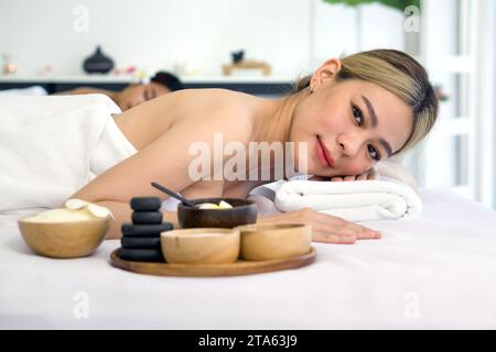 Ganzheitliches Luxus-Wellness-Erlebnis. Eine ruhige Frau, die sich gemütlich in einem beruhigenden Spa-Ambiente zurücklehnen kann, umgeben von Elementen, die Ruhe fördern. Stockfoto