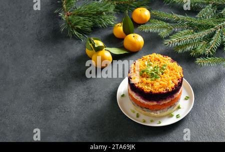 Shuba-Salat. Gekleideter Hering, Hering unter Pelzmantel. Weihnachtlicher Gemüsesalat mit Hering und gekochtem Gemüse. Dunkler Hintergrund mit frei Stockfoto