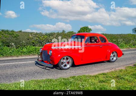 1940 40er Jahre Red American Chevrolet GMC. Große, benzinbetriebene Limousine mit 5700 ccm Hubraum, alte, restaurierte klassische Motoren, Autosammler, Autofahrer, historische Veteranenautos, die in Cheshire, Großbritannien, unterwegs sind Stockfoto