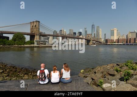 New York, USA - 25. Mai 2018: Menschen genießen den Blick auf das Finanzviertel Lower Manhattan vom Brooklyn Bridge Park aus. Stockfoto
