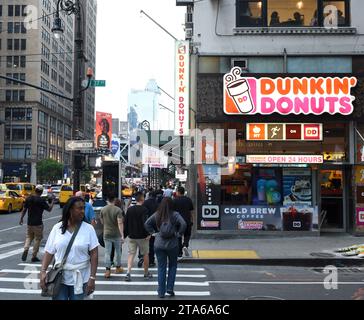 New York, USA - 27. Mai 2018: Menschen auf der Straße in der Nähe der Dunkin' Donuts in New York. Stockfoto