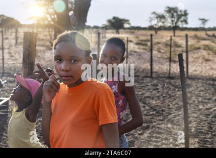 afrikanische Dorfkinder, die bei Sonnenuntergang im Garten spielen Stockfoto