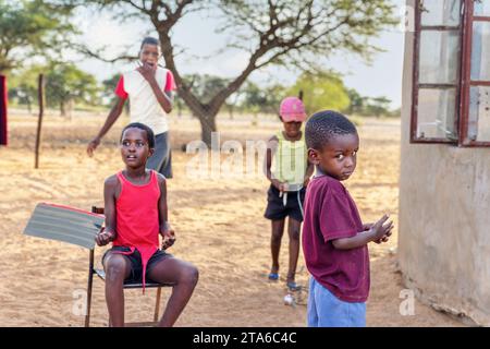 Gruppe afrikanischer Dorfkinder, die im Hof spielen Stockfoto