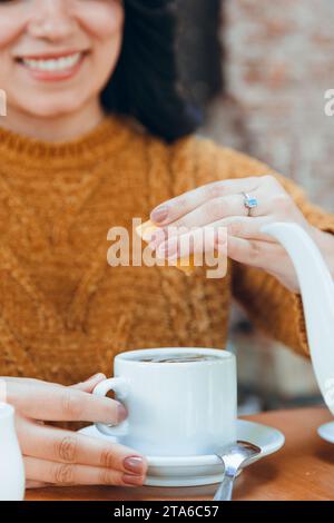 Vertikales Nahbild einer nicht erkennbaren Frau, die Zitrone in eine Tasse Tee drückt, Kopierraum Stockfoto