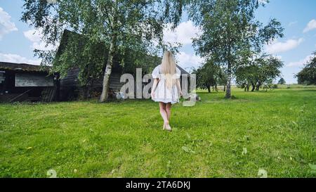 Ein Mädchen slawischer Erscheinung posiert auf dem Land bei der Scheune. Stockfoto