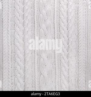 Die Textur eines weißen Strickpullovers in Nahaufnahme. Stockfoto