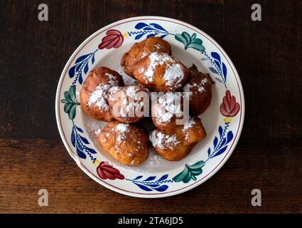 Traditionelles holländisches Oliebollen mit Puderzucker auf dem Teller Stockfoto