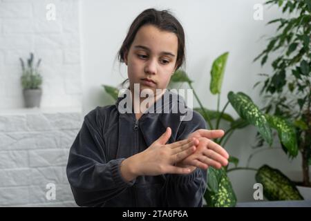 Wunderschönes, lächelndes, taubes Mädchen, das Gebärdensprache benutzt. Stockfoto