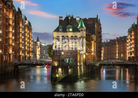 Historisches Wasserschloss im alten Lagerhaus Hamburgs zur blauen Stunde. Stockfoto