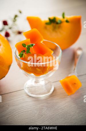 Zubereitete süße Kürbismarmelade in einer Glasschale auf einem Holztisch. Herbstrezepte. Stockfoto