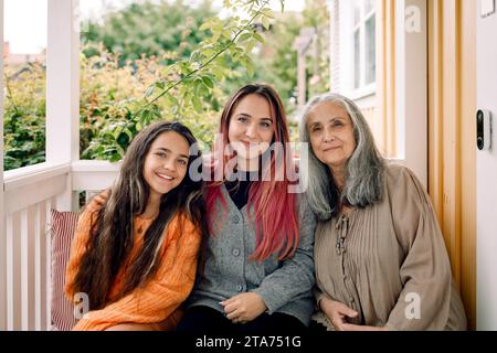 Porträt einer lächelnden Mehrgenerationsfamilie, die auf der Veranda sitzt Stockfoto