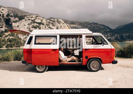 Seitenansicht einer jungen Frau mit Laptop im Van Stockfoto