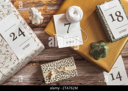 Overhead-Ansicht von Geschenken für einen Adventskalender neben Weihnachtsschmuck Stockfoto