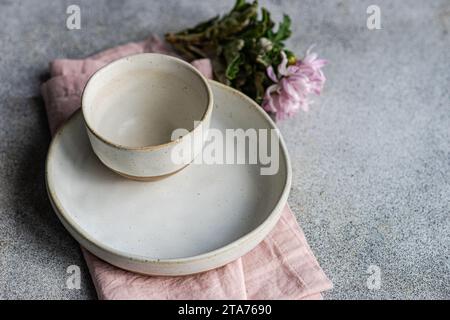 Draufsicht auf eine Keramikschale und einen Teller mit einer rosa Chrysanthemenblume Stockfoto