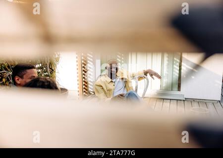 Lächelnder junger Mann, der Spaß mit Freunden auf der Party hat Stockfoto