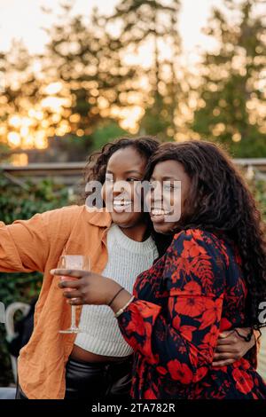 Glückliche junge Freundinnen, die zusammen auf der Dinnerparty genießen Stockfoto