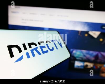 Mobiltelefon mit Logo des amerikanischen Fernsehvertriebs DirecTV LLC vor der Website. Fokussieren Sie sich auf die linke Mitte des Telefondisplays. Stockfoto